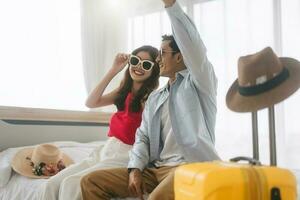 giovane adulto sud-est asiatico coppia viaggiatore indossare occhiali da sole a casa nel Camera da letto su giorno foto