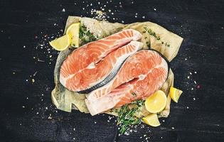 bistecche di salmone su sfondo nero vista dall'alto foto filtrata in stile vintage
