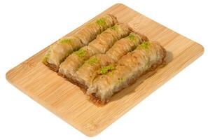 pezzi di al forno baklava nel miele e cosparso con pistacchi su un' di legno tavola foto