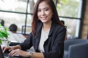 donne asiatiche di affari che utilizzano computer portatile nella caffetteria foto