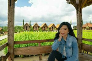 indonesiano femmina guardare contento con riso campo Visualizza paesaggio foto