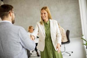 due professionisti si stringono la mano in un ufficio foto