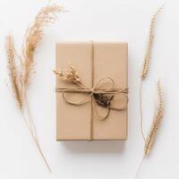 superiore Visualizza di rustico confezionato regalo scatola legato con tela ruvida filo, d'oro secco erba su bianca sfondo. generativo ai. foto