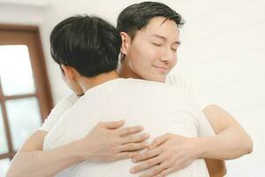 contento asiatico gay coppia abbraccio insieme su divano. asiatico lgbt coppia Abbracciare una persona insieme a casa. diversità di lgbt relazioni. un' gay coppia concetto. lgbt Multi relazione. foto