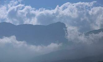 montagna scenario, nuvole su superiore di un' montagna gamma scendere senza intoppi verso il basso. foto