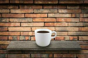 caffè tazza su il di legno al di sopra di pietra parete sfondo foto