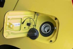 selettivo messa a fuoco su il giallo auto carburante serbatoio copertina con un' avvertimento utilizzando ottano carburante numero 92. morbido messa a fuoco foto