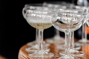 champagne frizzante in bicchieri sul tavolo di legno su sfondo nero