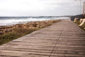 bella passerella pedonale in legno lungo la riva del mare