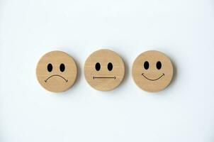 felice, triste e neutro emoticon facce su di legno cerchio con bianca sfondo coperchio. cliente feedback, soddisfazione e valutazione concetto foto