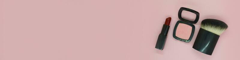 striscione. cosmetico spazzola, rosa arrossire e rosso rossetto foto