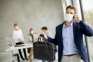 imprenditore prendendo il telefono con la maschera foto