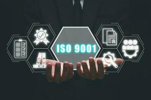 iso 9001 concetto, uomo d'affari mano Tenere iso 9001 icona su virtuale schermo. foto