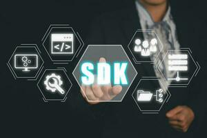 sdk - Software sviluppo kit programmazione linguaggio tecnologia concetto, attività commerciale donna mano toccante sdk icona su virtuale schermo. foto