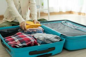 viaggio Borsa. femmina siamo controllo il dettaglio e quantità di elementi Usato durante il viaggio. giovane donne siamo preparare Abiti e personale effetti personali. imballare il tuo bagaglio prima viaggio. foto