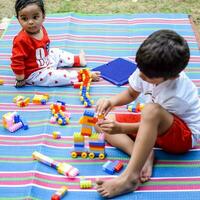 Due contento ragazzi nel società parco, contento asiatico fratelli chi siamo sorridente felicemente insieme. fratelli giocare all'aperto nel estate, migliore gli amici. bambino piccolo bambino ragazzo giocando con il suo contento fratello nel il giardino foto