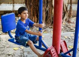 asiatico ragazzo fare routine esercizio nel società parco durante il mattina volta. carino poco ragazzo esercizio e Palestra per mantenere lui stesso in forma per vita. del bambino esercizio all'aperto sparare foto