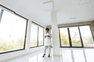 medico in piedi in un ufficio moderno con tablet foto