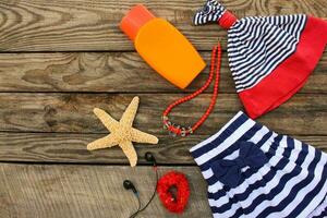 estate figli di capi di abbigliamento e spiaggia Accessori per il tuo mare vacanza su il vecchio di legno sfondo. tonica Immagine. foto