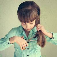 ragazza tagliare sua capelli. tonica Immagine. foto