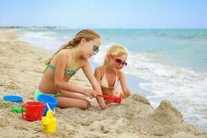 bambini giocare con sabbia su spiaggia. foto