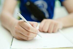 asiatico adolescenziale alunno Scrivi compiti a casa, studia lezione per esame in linea apprendimento formazione scolastica. foto