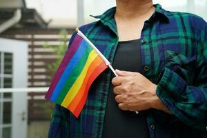 donna asiatica con bandiera arcobaleno, diritti dei simboli lgbt e uguaglianza di genere, mese dell'orgoglio lgbt a giugno. foto