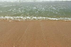 bellissimo onde su il sabbia spiaggia sfondo. foto