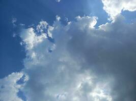 nuvoloso cielo con bianca e buio nuvole foto. blu cielo con nube e raggio di sole sfondo. foto