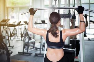 donna che utilizza lavoro fuori macchina in palestra foto