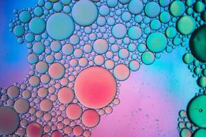 Multi colorato olio cerchi su il acqua, colorato sfondo foto