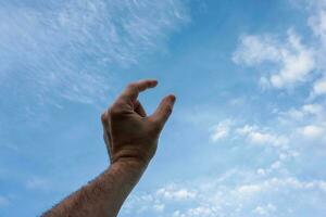 mano su Esprimere a gesti nel il blu cielo, sentimenti e emozioni foto