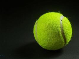 palla da tennis su sfondo nero foto