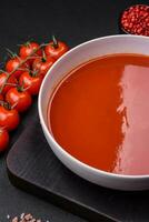 delizioso fresco Gazpacho con briciole di pane, sale e spezie nel un' ceramica piatto foto