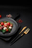 delizioso fresco insalata con Mozzarella formaggio, ciliegia pomodori, erbe aromatiche, sale e spezie foto