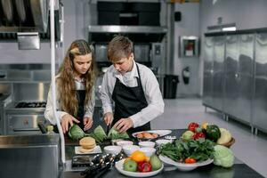 adolescenti imparare a partire dal esperto chef a culinario scuola per preparare ingredienti e creare un' varietà di gustoso pasti. un' pratico attività collegato loro sensi di gusto e odore è fabbricazione hamburger. foto