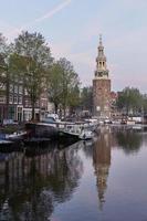 una delle chiese di Amsterdam nei Paesi Bassi unica con scena della città lungo il canale nella luce naturale del mattino foto