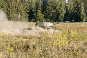 Mosca, Russia, 25-08-2018, esposizione di militare attrezzatura, Schermo di militare attrezzatura nel azione. un' militare serbatoio nel movimento contro il sfondo di verde alberi. foto