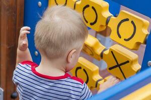 un' poco ragazzo con entusiasmo giochi su il terreno di gioco. successo, creativo idee e gli sport concetti. figli di terreno di gioco. foto