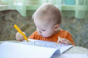 il sviluppo di bambini. disegno classi a casa. noi siamo sviluppando indipendentemente nel un' crisi. il bambino disegna. foto