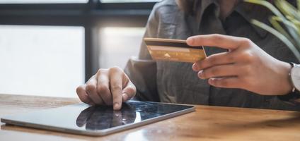 acquisti online. donna asiatica che digita le informazioni della carta di credito dalla tastiera del tablet per lo shopping online. foto