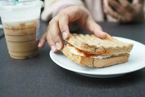 donne Tenere Sandwich e carta caffè tazza all'aperto , foto