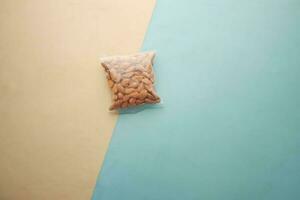 pelato arachidi nel un' plastica pacchetto su colore tavolo foto