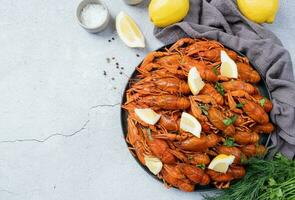 superiore Visualizza di cucinato gamberi piatto con limoni e spezie su cemento sfondo foto