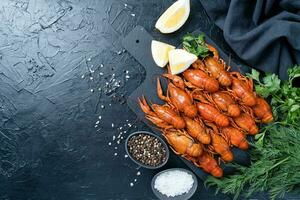 cucinato gamberi su piatto con limoni e spezie su buio sfondo foto