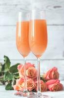 Due bicchieri di bellini cocktail con mazzo di Rose foto