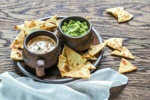 ciotole di guacamole e queso con tortilla chips foto