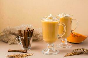 zucca dalgona caffè con cannella nel bicchieri su un' beige sfondo. autunno fatti in casa bevande foto