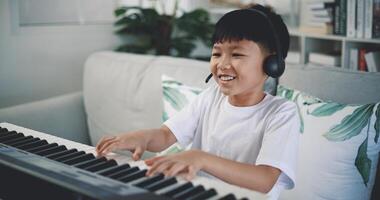 carino ragazzo godere per apprendimento giocando pianoforte a casa foto