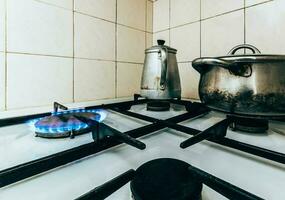 naturale gas ardente su stufa con pentole e pentole nel il cucina foto